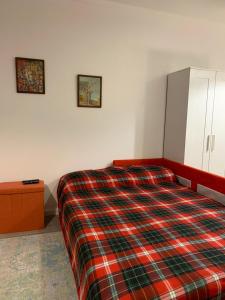 um quarto com uma cama com um cobertor xadrez em Braga Forum House em Braga