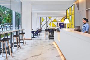 Una donna in piedi al bancone di un ristorante con un computer di Holiday Inn Express Singapore Serangoon, an IHG Hotel a Singapore