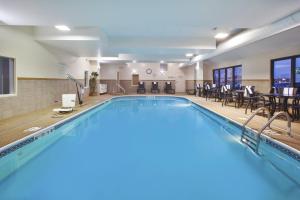 una piscina con sillas y mesas en una habitación de hotel en Holiday Inn Express Tiffin, an IHG Hotel, en Tiffin