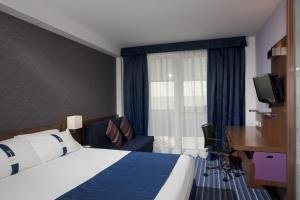 a hotel room with a bed and a desk and a television at Holiday Inn Express Madrid Leganes by IHG in Leganés +21 photos