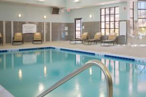 毛米的住宿－Staybridge Suites Toledo/Maumee, an IHG Hotel，一个带椅子和桌子的大型游泳池