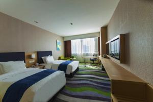 a hotel room with two beds and a flat screen tv at Holiday Inn Express Jinan High-Tech Zone by IHG in Jinan