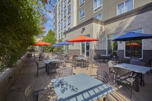 an outdoor patio with tables and chairs and umbrellas at Holiday Inn Express : Eugene - Springfield by IHG in Springfield