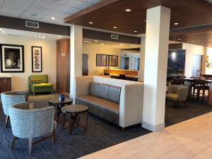 a living room with a table and chairs at Holiday Inn Express & Suites - Springfield North, an IHG Hotel in Springfield