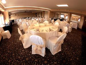 Centereach的住宿－長島石溪快捷假日酒店，宴会厅配有白色的桌子和白色的椅子