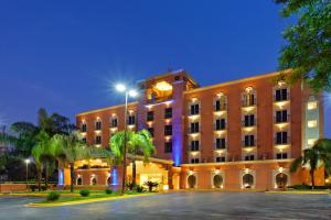 a large building with palm trees in front of it at Holiday Inn Express Monterrey Galerias-San Jeronimo, an IHG Hotel in Monterrey