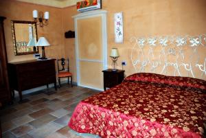 a bedroom with a red bed and a mirror at Agriturismo Casacchella in San Nico