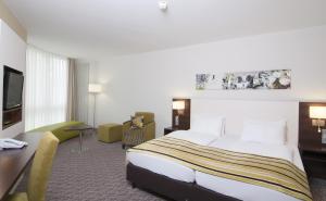 Habitación de hotel con cama grande y escritorio. en Holiday Inn Munich Unterhaching, an IHG Hotel, en Unterhaching