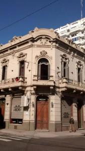 an old white building on the corner of a street at Kymani House in Rosario