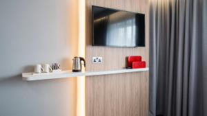 a flat screen tv on a wall with a shelf at Holiday Inn Express Oxford Kassam Stadium, an IHG Hotel in Oxford