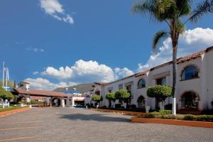 un bâtiment avec un palmier à côté d'une rue dans l'établissement Holiday Inn Express Morelia, an IHG Hotel, à Morelia
