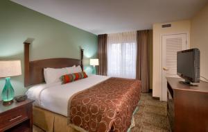 a hotel room with a bed and a flat screen tv at Staybridge Suites Peoria Downtown by IHG in Peoria +36 photos