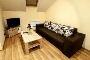 a living room with a black couch and a table at Wonderful flat on city center (Mukachivska 4/16) in Uzhhorod