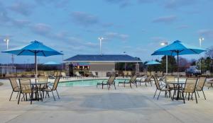 grupa stołów i krzeseł z niebieskimi parasolami w obiekcie Holiday Inn Express Monticello, an IHG Hotel w mieście Monticello