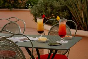 a green table with two drinks on it at easyHotel Nice Old Town in Nice