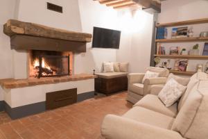 sala de estar con chimenea y TV en Casale l’oliveta, en Buti
