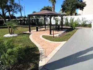 a picnic area with an umbrella and a sidewalk at Smart Stay Inn - Saint Augustine in St. Augustine