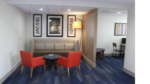 una sala de espera con sofá y 2 sillas rojas en Holiday Inn Express Orlando - South Davenport, an IHG Hotel en Davenport