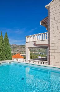 a swimming pool in front of a house at Apartment Barbara with Private pool in Dubrovnik