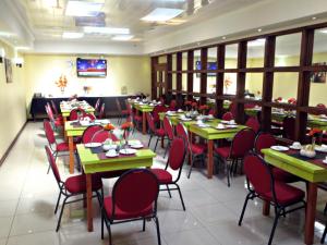 ein Restaurant mit grünen Tischen und roten Stühlen in der Unterkunft Hotel Newen in Temuco