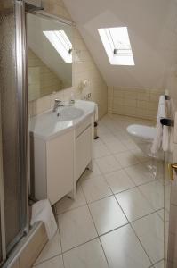 ein Bad mit einem Waschbecken und einem WC in der Unterkunft Alfa Apartment Hotel in Neu Isenburg