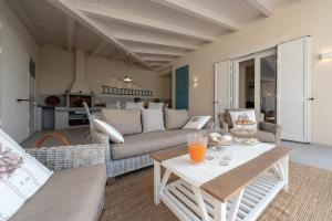 een woonkamer met een bank en een tafel bij Villa Galene - IsulaTravel in Ispica