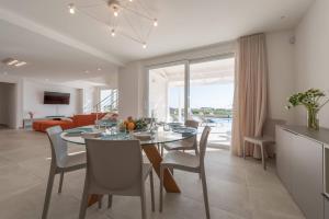 モーディカにあるVilla White - IsulaTravelのテーブルと椅子のあるダイニングルームとリビングルーム