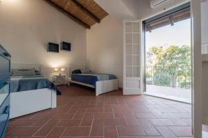 a bedroom with a bed and a large window at Villa Althea - IsulaTravel in Modica