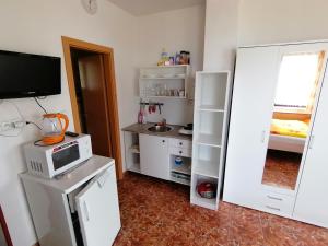 una pequeña cocina con armarios blancos y microondas en Penzion Nad jezerem, en Pavlov