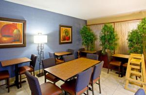 a dining room with tables and chairs and plants at Holiday Inn Express Scottsdale North by IHG in Scottsdale