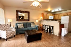 a living room with a couch and a kitchen at Shady River Oasis in New Braunfels