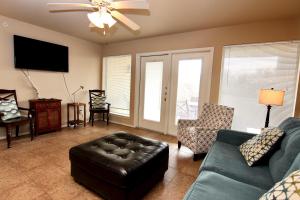 a living room with a couch and a tv at Shady River Oasis in New Braunfels