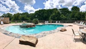 a swimming pool with a fountain in a yard at Shady River Oasis in New Braunfels