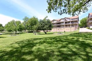 a park with benches and trees in front of a building at Shady River Oasis in New Braunfels