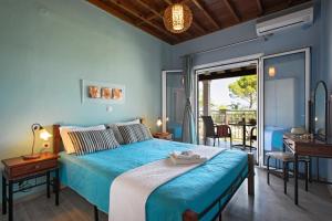a blue bedroom with a bed and a balcony at Sand and Sea in Kavos