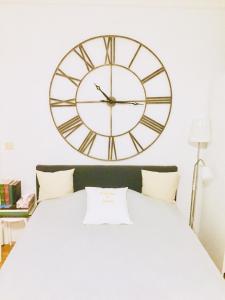 a large clock on the wall above a bed at Welcome to Messe! Two-bedroom SmartApartment &Balcony in Hannover