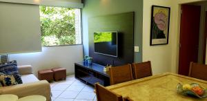 a living room with a table and a tv at Lindo apartamento em Ipanema - RJ in Rio de Janeiro