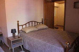 una camera da letto con un letto e un tavolo con una lampada di Casa do Sapateiro a Sobral de São Miguel
