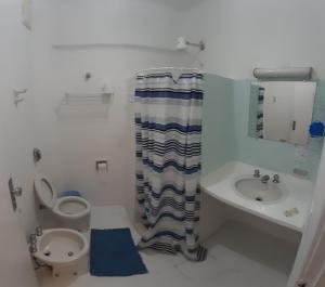 a bathroom with a toilet and a sink at Apart-Hotel Flat Cavalinho Branco in Águas de Lindoia