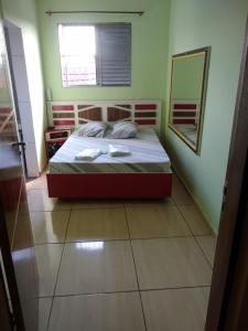 um quarto com uma cama com um espelho e uma janela em Hotel Momentos em São Paulo