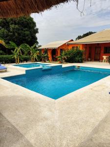 - une piscine en face d'une maison dans l'établissement B & B Mariamacounda, à Toubakouta