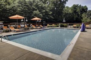 una piscina con sillas y sombrillas en Holiday Inn Express Richmond-Mechanicsville, an IHG Hotel en Mechanicsville