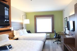 a hotel room with two beds and a desk at Holiday Inn Express Hotel & Suites Mansfield by IHG in Mansfield