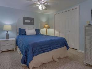 - une chambre avec un lit bleu et un ventilateur de plafond dans l'établissement Cotton Bayou 4H, à Orange Beach