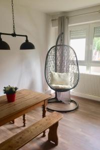 a living room with a rattan chair and a table at Cosy and You in Colmar