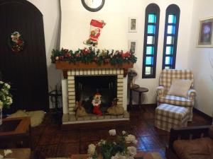 una sala de estar con chimenea y adornos navideños en Casa Innsbruck, en Gramado