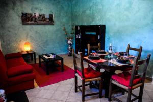 a dining room with a table and a red couch at Le Suite Bracciano in Bracciano