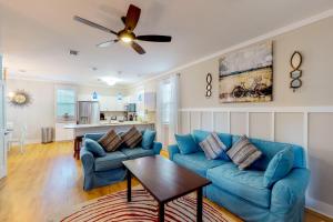 a living room with blue couches and a ceiling fan at Barefoot Cottages #C59 in Highland View
