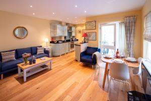 ein Wohnzimmer mit einem blauen Sofa und einem Tisch in der Unterkunft 4 Wards Place in Aldeburgh
