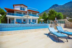 una casa con due sedie e una piscina di Villa Alkin a Kalkan